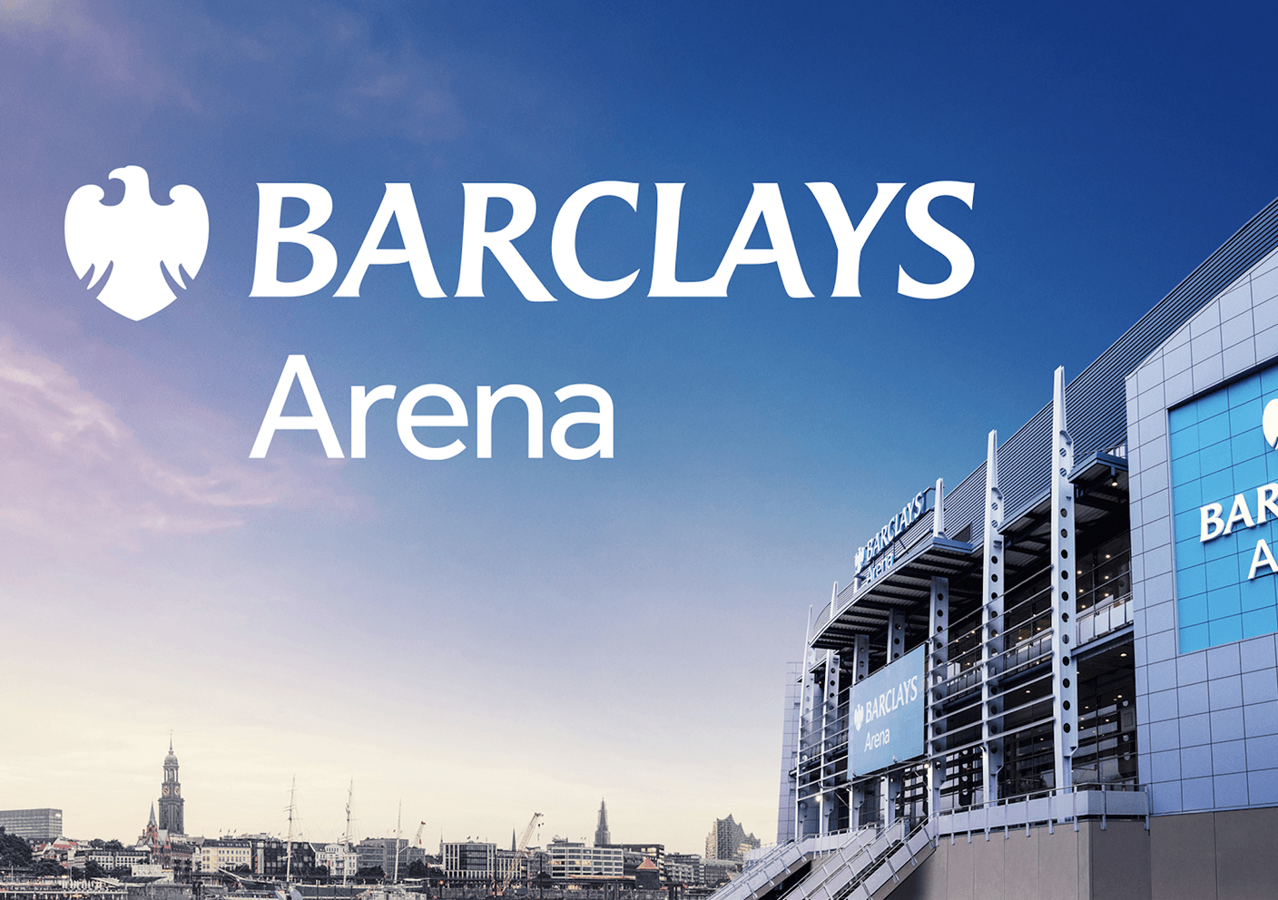 Barclays Arena mit großem Logo und Schriftzug, modernes Gebäude vor Stadtsilhouette bei blauem Himmel.